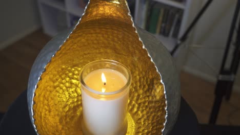 Slow-slider-shot-of-candle-glowing-in-orb-candle-holder,peaceful