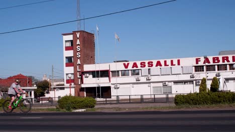 A-truck-moves-right-to-left-through-National-Route-33,-in-front-of-harvester-manufacturer-Vassalli's-plant,-as-a-bike-goes-the-opposite-way