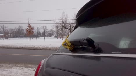 Small-vehicle-wrapped-in-yellow-caution-tape-after-motor-vehicle-accident-MVA-car-accident-on-snowy-day-in-winter