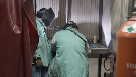 Trade-school-welding-instructor-working-with-a-female-student-women-in-manufacturing