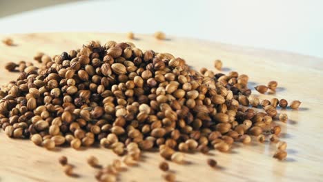 Coriander-Seeds-Rotating-on-a-Wooden-Board