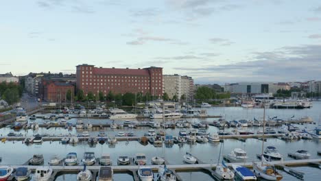 Slow-aerial-pan-of-boats-in-a-dock-along-the-waterfront-of-Helsinki,-Finland
