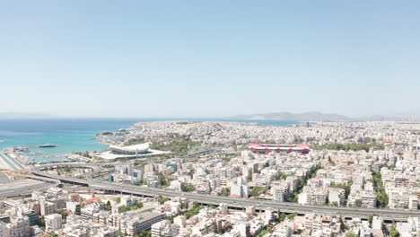 Aerial-drone-flight-towards-the-two-stadiums-of-Sef-and-Karaiskaki-over-the-city-of-Piraeus