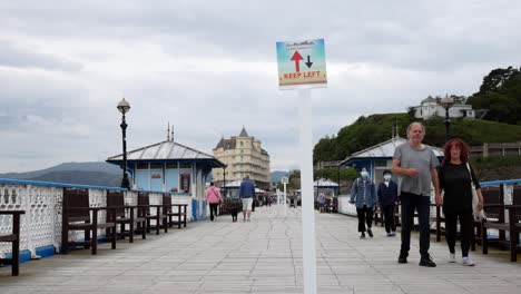 Llandudno-seaside-resort-town-pier-tourist-attraction-corona-virus-social-distancing-sign-on-boardwalk