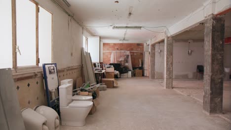 Panning-around-empty-desolate-building-site-room-in-a-commercial-building-with-exposed-walls-and-cables