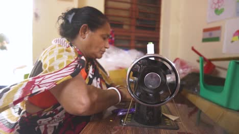 Alone-rural-Indian-woman-worker-stitching-cloth-in-sewing-machine-indoor,-slow-motion