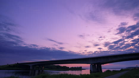 Der-Himmel-Färbt-Sich-Lila,-Während-Die-Sonne-Hinter-Dieser-Autobahnbrücke-Langsam-Untergeht
