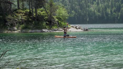 Tourist-in-SUP-board-at-Lake-Eibsee,-Germany