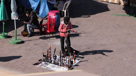 Straßenhändler,-Der-Miniaturstatuen-In-Der-Straße-Von-Marrakesch,-Marokko,-Poliert-Und-Verkauft