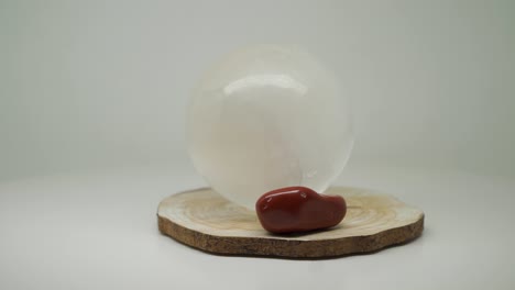 Weiße-Runde-Kristallkugel-Und-Kleiner-Roter-Stein-Oben-Auf-Dem-Drehteller---Nahaufnahme