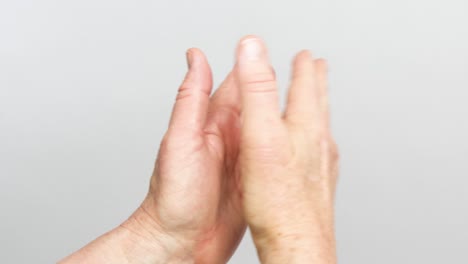 A-view-of-hands-claping-from-the-back-of-the-wrists-is-isolated-on-a-white-background