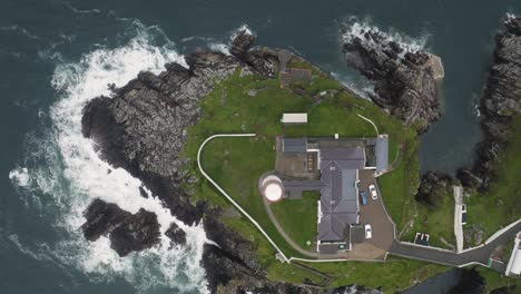 Top-down-aerial-drone-view-of-solitary-lighthouse-overlooking-the-North-Atlantic-Ocean