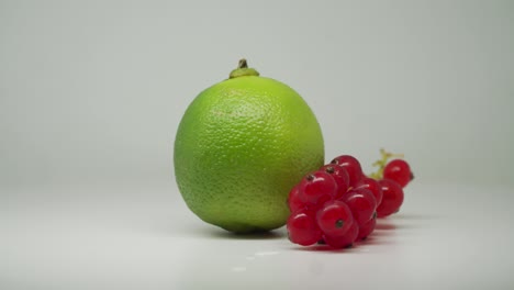 Freshly-Picked-Red-Currants-And-Green-Lime-Rotating-Clockwise---Close-Up-Shot