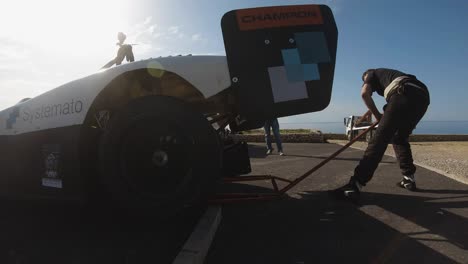 Man-Jacked-Up-The-Rear-Part-Of-A-Racing-Car-For-Maintenance-Check-At-The-Hill-In-Imtahleb-Malta---Closeup-GoPro-Shot