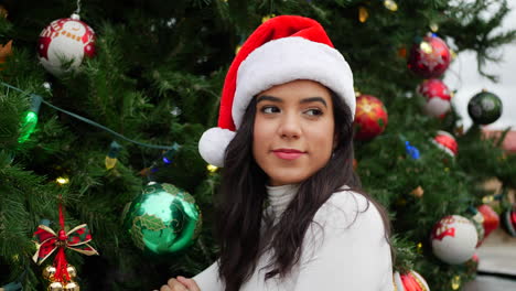 Eine-Glückliche-Junge-Frau-Mit-Weihnachtsmütze-Feiert-Weihnachten-Und-Die-Feiertage-Mit-Einem-Festlichen-Baum-Und-Ornamenten