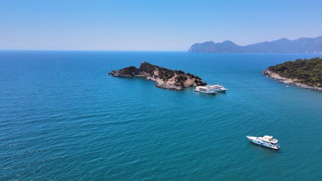 Drone-shooting-endless-sea-with-pleasure-boats-small-islands-and-mountain-ranges