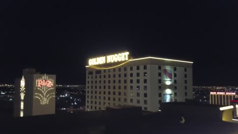 Antena-4k:-Toma-Aérea-Dinámica-Sobre-El-Hotel-Y-Casino-Golden-Nugget-En-Las-Vegas-Con-Las-Luces-De-La-Ciudad-De-Fondo-Al-Atardecer