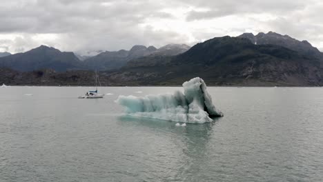 Luftaufnahme-Eines-Eisbergs-Und-Eines-Bootes-Im-Kalten-Wasser-An-Der-Küste-Alaskas-An-Einem-Bewölkten-Tag