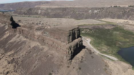 Panoramic-Orbit-of-an-enormous-butte-in-the-middle-of-Sun-Lakes-Dry-Falls-State-Park,-aerial