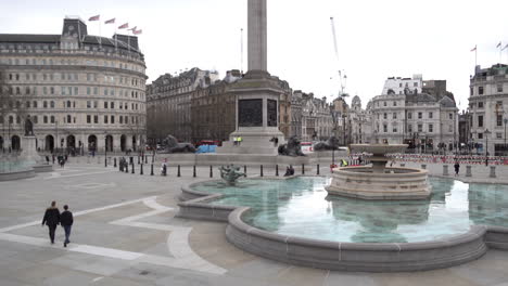 A-few-people-walk-across-an-empty-Trafalgar-Square-he-day-after-Prime-Minister-Boris-Johnson-warns-the-UK-population-to-avoid-all-non-essential-social-contact-due-to-the-Coronavirus-outbreak