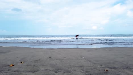 Mann-Surft-Am-Kuta-Beach-Auf-Bali-Inmitten-Der-Reisebeschränkungen-Des-Coronavirus-Covid-19