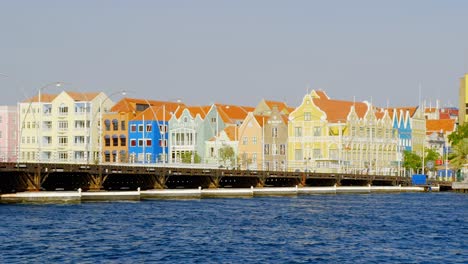 Queen-Emma-Bridge-With-Colorful-And-Historic-Buildings-On-The-Background-In-Punda,-Willemstad,-Curacao