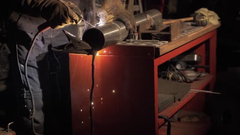 Welder-welding-stainless-steel-pipe-together-using-shielded-metal-arc-welding