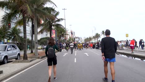 Gente-Caminando-Por-La-Playa-Durante-Una-Protesta-En-Río-De-Janeiro,-Brasil