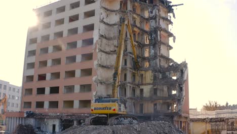 Sun-glare-on-a-demolition-site-with-construction-machinery-busy-in-the-process-of-demolition-of-the-building