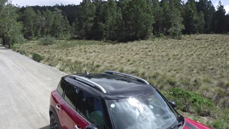 Flying-over-red-Mini-Countryman-car-parked-along-country-road-in-rural-area