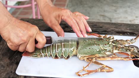 Close-up-shot-chef-with-knife-cut-live-Lobster-in-half,-kitchen-outdoor