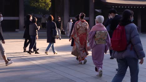 Personas-Con-Máscaras-Faciales-Y-Ropa-Típica-De-Kimono-Japonés-En-El-Santuario-Meiji-Durante-La-Crisis-De-La-Corona