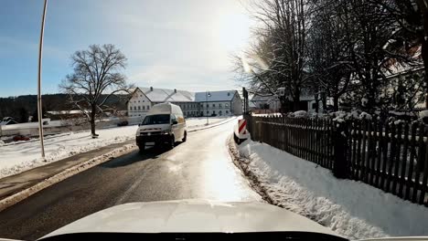 Driving-past-the-popular-abbey-Schäftlarn-or-Schaeftlarn-in-southern-bavaria,-a-4k-hyperlapse-winter-drive-through-the-bavarian-village-where-the-popular-white-monastery-is-situated