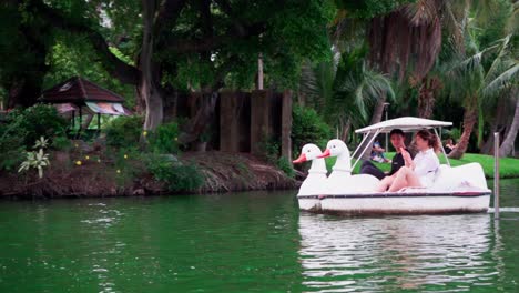 A-slow-motion-clip-of-a-young-couple-riding-on-a-white-swam-themed-paddle-boat-in-Bangkok-during-during-social-distancing