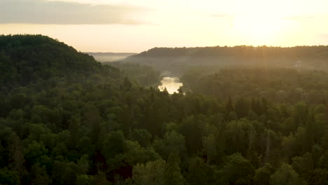 Amazing-sunset-over-European-forest-and-river,-beautiful-aerial-landscape