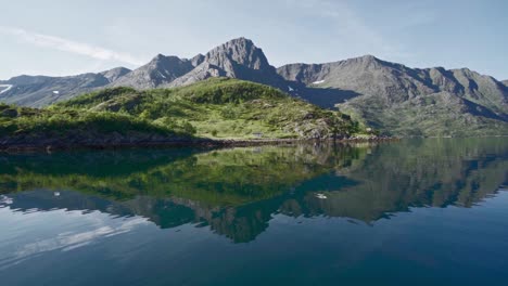 Hermosa-Vista-De-Las-Crestas-Reflejadas-En-El-Lago-De-Agua-Prístina-En-Noruega-Durante-El-Día-Soleado