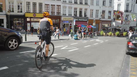 Police-officer-bike-driver-cycling-in-the-city-center-on-a-summer-day---Brussels,-Belgium