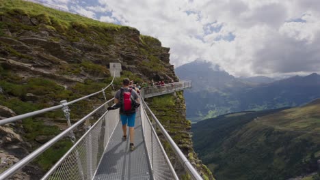 Gente-Cruzando-Un-Puente-En-El-Primer-Acantilado-En-Grindelwald,-Suiza