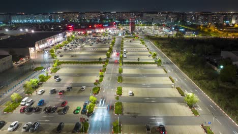 Drone-night-hyperlapse-of-car-traffic-in-parking-lot,-Militari-Shopping,-Bucharest