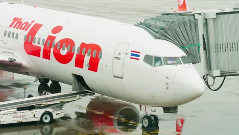 Thai-Lion-Airlines-dock-at-the-concourse-as-they-prepare-for-departure-with-ground-staff-around-on-a-rainy-day-at-Don-Mueang-International-Airport-DMK