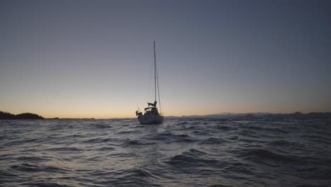 Sailboat-in-Wavy-Sea-at-Twilight,-Slow-Motion
