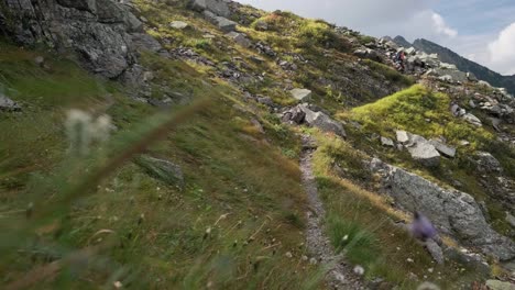 Plano-General-De-Un-Excursionista-Masculino-Caminando-Por-Un-Camino-Rocoso-En-La-Montaña-Durante-El-Día-Soleado