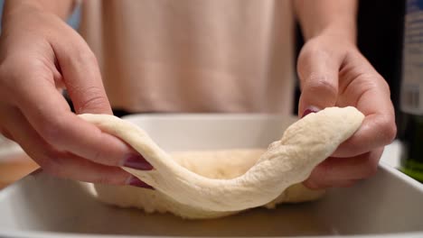 Woman-hands-roll-out-pizza-dough-in-a-pan