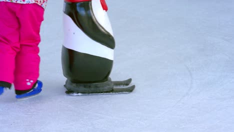 Close-up-on-kids-learning-ice-skating-on-artificial-ice-rink