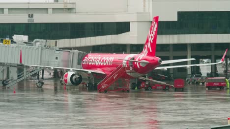 AirAsia-Airlines-dock-at-the-concourse-as-they-prepare-for-departure-with-ground-staff-around-on-a-rainy-day-at-Don-Mueang-International-Airport-DMK