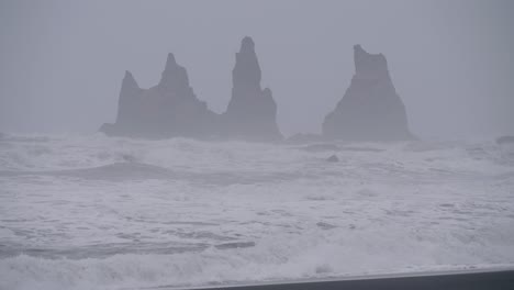 Static,-shot,-of-waves-hitting-a-black-cliffs,-on-the-arctic-sea,-on-a-cloudy,-stormy-day,-at-Diamond-beach-Islandia,-in-South-coast-of-Iceland