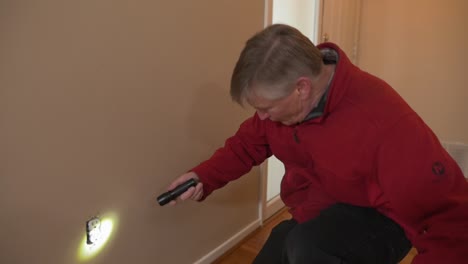 House-inspector-examines-walls-and-electrical-outlet