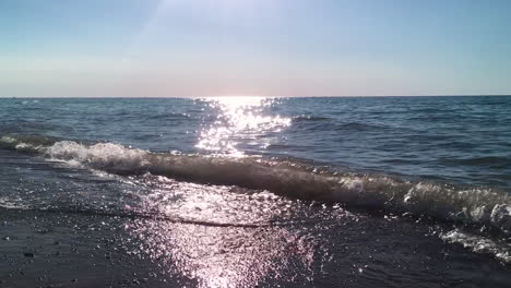 sun-shimmering-on-lake-while-the-waves-crash