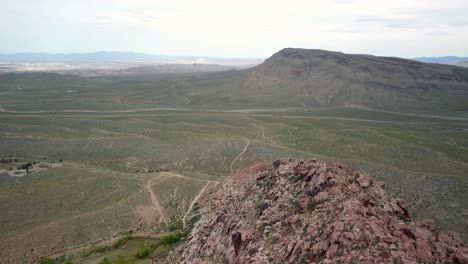 4K-Luftaufnahme,-Die-Die-Gipfel-Des-Red-Rock-Canyon-Hinunterfliegt,-Mit-Las-Vegas-Im-Fernen-Hintergrund