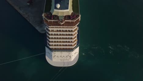 Aerial-topdown-view-with-sideways-camera-movement-of-a-big-cruise-ship-with-people-on-the-upper-deck-4K